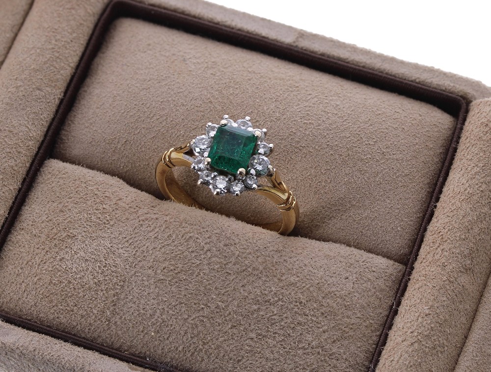 18ct emerald and diamond cluster ring, the emerald 0.66ct approx, in a setting of twelve diamonds,