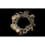 A Vintage Good Quality Silver Fancy Link Bracelet with over 20 charms plus silver coins.