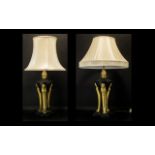 A Pair of Elegant Brass Lamps in the French Regency taste with three carriers holding the font in a