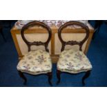 A Pair of Victorian Mahogany Balloon Back Parlour Chairs with a carved shaped splat,