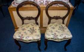 A Pair of Victorian Mahogany Balloon Back Parlour Chairs with a carved shaped splat,