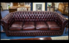 A Large Four Seater Chesterfield Sofa in antique burgundy red leather with button back finish to