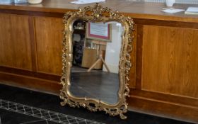 Gilt and Gesso Carved Wood Mirror with a Shaped Bevel Edge, The Frame In The Rococo Style,