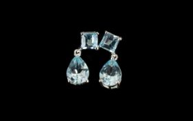 Sky Blue Topaz Drop Earrings, each earring comprising a pear cut topaz suspended below a square cut,