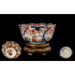 Japanese 19th Century Imari Pallet Bowl raised on a carved ornate wooden display stand.