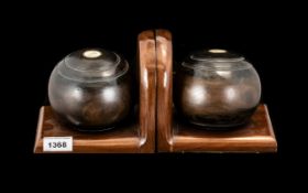 Two Crown Green Bowls together with holders to form two book ends. The bowls marked Thomas Royal.