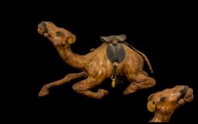 Leather Clad Reclining Camel with saddle on its back, with stirrups.