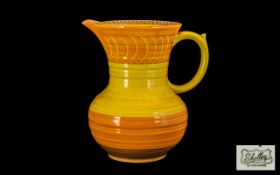 An Art Deco Shelley Jug decorated in bright yellow colours. Measuring 8 inches in height.