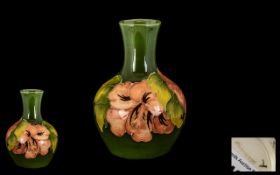 Moorcroft Small Tubelined Global Shaped Vase - 'Coral Hibiscus' design on green ground.