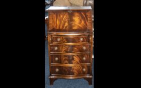 A Small Mahogany Bow Fronted Reproduction Bureau with a fitted interior below four graduated