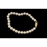 Simulated Pearl Bracelet with decorative yellow metal clasp. In excellent condition.