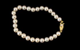 Simulated Pearl Bracelet with decorative yellow metal clasp. In excellent condition.