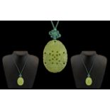 Chinese Green Jadite Carved oval Shaped Pendant - of fine colour with floral decorations.