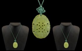 Chinese Green Jadite Carved oval Shaped Pendant - of fine colour with floral decorations.