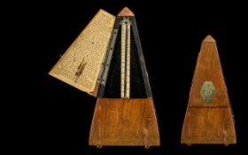 Swiss Made Wooden Metronome raised on four ball feet.