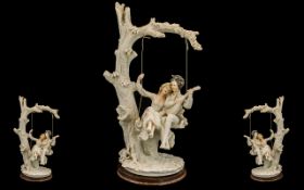 Large Resin Figure of a Couple on a Swing depicting a tree with a swing and a courting couple,