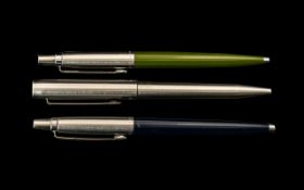 Three Parker Pens. Comprising one stainless steel, one blue, and one green. Please see images.