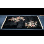 Attractive Wool Rug in black with fringing and decorative coloured floral design.