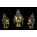 Small Indian Bronze Buddha Head with spiral form hair and elongated pierced ears with a serene face.