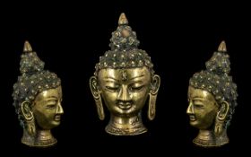 Small Indian Bronze Buddha Head with spiral form hair and elongated pierced ears with a serene face.