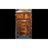 A Small Mahogany Bow Fronted Reproduction Bureau with a fitted interior below four graduated