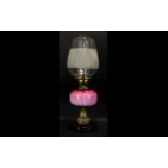 An Early 20th Century Oil Lamp Of Typical form with pink ombre glass reservoir,