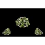 Peridot Flower Cluster Ring, an openwork floral cluster mount set with oval cut peridots of 4.
