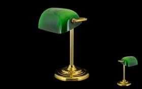 A Brass Desk/Bankers Lamp with green polished shade raised on a circular base.