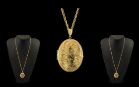 A 9ct Gold Oval Locket engraved floral decoration to the front.