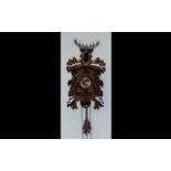 Black Forest Carved Cuckoo Clock of traditional form, front carved with squirrels,