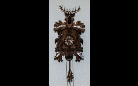 Black Forest Carved Cuckoo Clock of traditional form, front carved with squirrels,