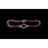 Ruby Line Bracelet with Central Infinity Motif, 23cts, a line of oval cut rubies with a solitaire,