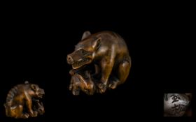 A Japanese Carved Boxwood Netsuke In The Form of a Starving Wolf.