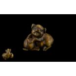 A Japanese Carved Boxwood Netsuke In The Form of a Pig Frolaking with Fruit,