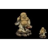 Small Chinese Stoneware Figure of Hotei, on a rocky base, carrying a sack on his back; 8.