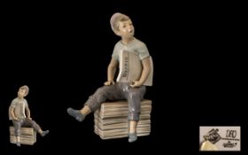 Nao Figure of a Paper Boy Early porcelain figure of a Newspaper Boy Seller Sitting on a Box.