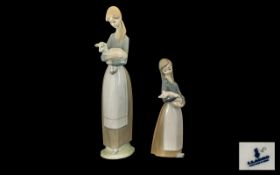 Lladro Handpainted Porcelain Figures (2). 1. Young woman carrying a lamb. Height 10.5" - 26.5 cm.