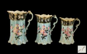 Set of Three Graduated Victorian Pottery Floral Decorated Milk Jugs on a turquoise coloured ground