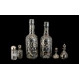 Six Silver Mounted Glass Bottles comprising pair of floral silver overlaid bottle shaped decanters,
