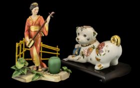 Two Porcelain Figures comprising a decorative Oriental style dog from the Franklin Mint,