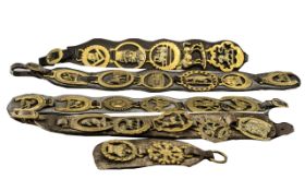 Large Amount of Antique Horse Brasses suspended on leather straps, five in total,