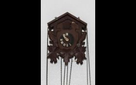 Wooden Swiss Cuckoo Clock with pine cone pendulums. Clock surrounded by wooden birds.