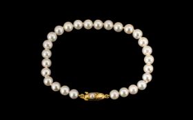 Simulated Pearl Bracelet with decorative yellow metal clasp. In excellent condition.