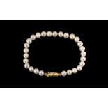 Simulated Pearl Bracelet with decorative yellow metal clasp. In excellent condition.