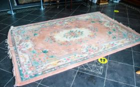 A Chinese Wool Rug 100% Wool. Peach ground with fringed edges, centre circular cream relief.