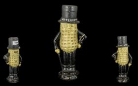 Cast Iron Replica 'Planters Pea-nut Bank', a peanut wearing a top hat,