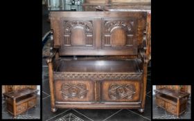 An Oak Folding Top Table Monks Bench with a lift up lidded seat with open arms with two carved