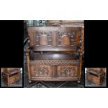 An Oak Folding Top Table Monks Bench with a lift up lidded seat with open arms with two carved