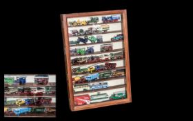 A Glazed Wall Display containing a quantity of die cast models to include tractors,