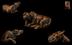 An Oriental Boxwood Netsuke in the form of water buffalo, signed to the base.